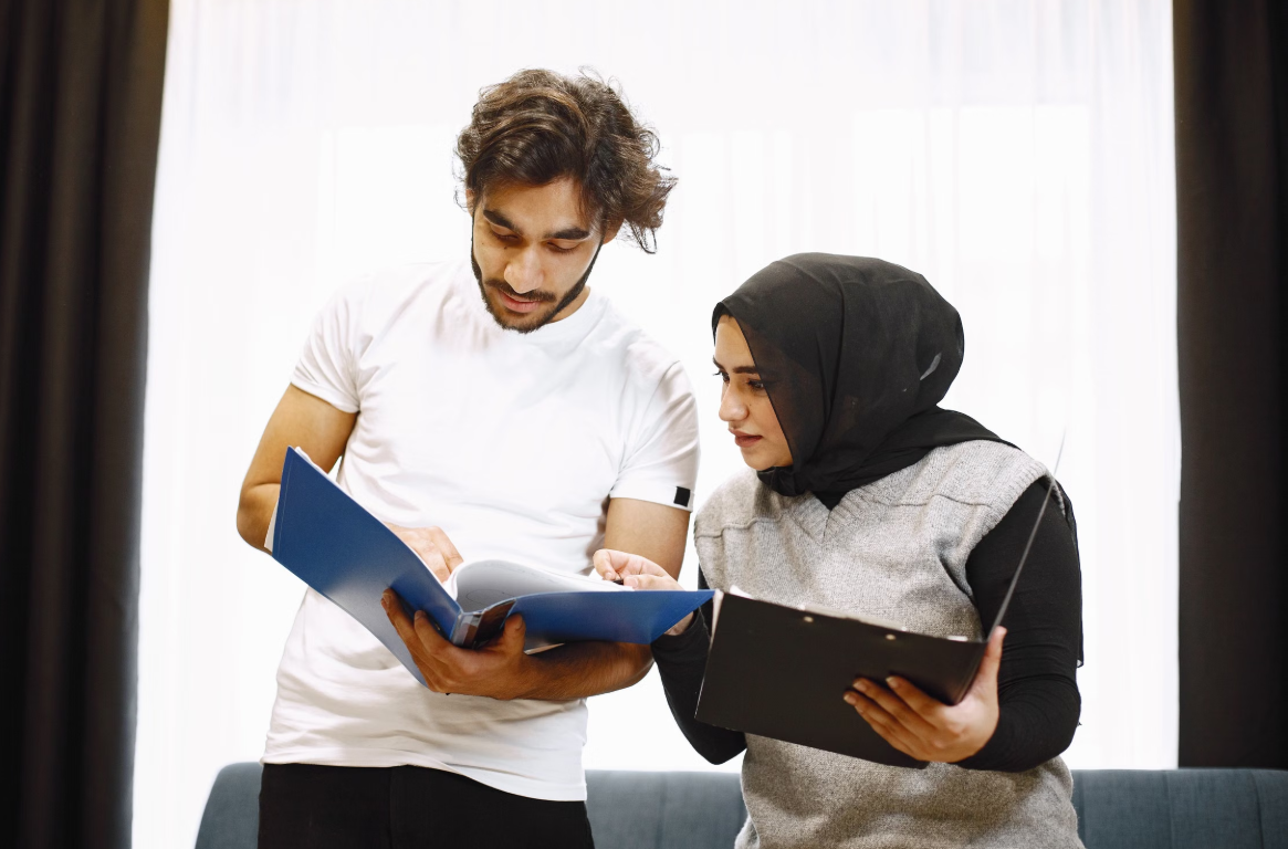 Consultant reviewing quality management documents with a small business team