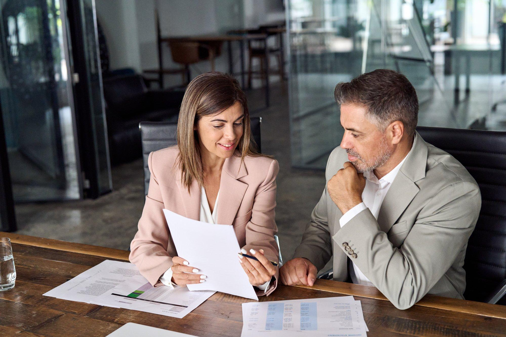 Business Compliance Support 1 Two business professionals reviewing compliance documents together